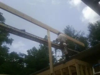 Carpenter setting a ridge beam over a new addition frame — Ice Dam Removal by Roofing Brothers in Woodleaf