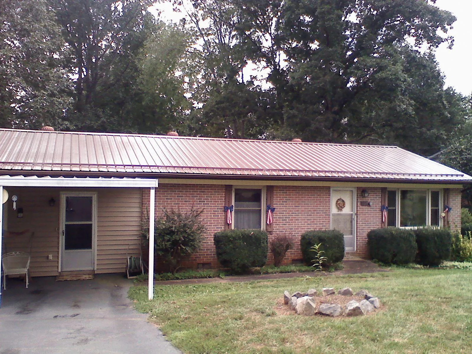 Bronze metal roof and carport on a brick ranch home — Roof Repair work by our crew in Woodleaf