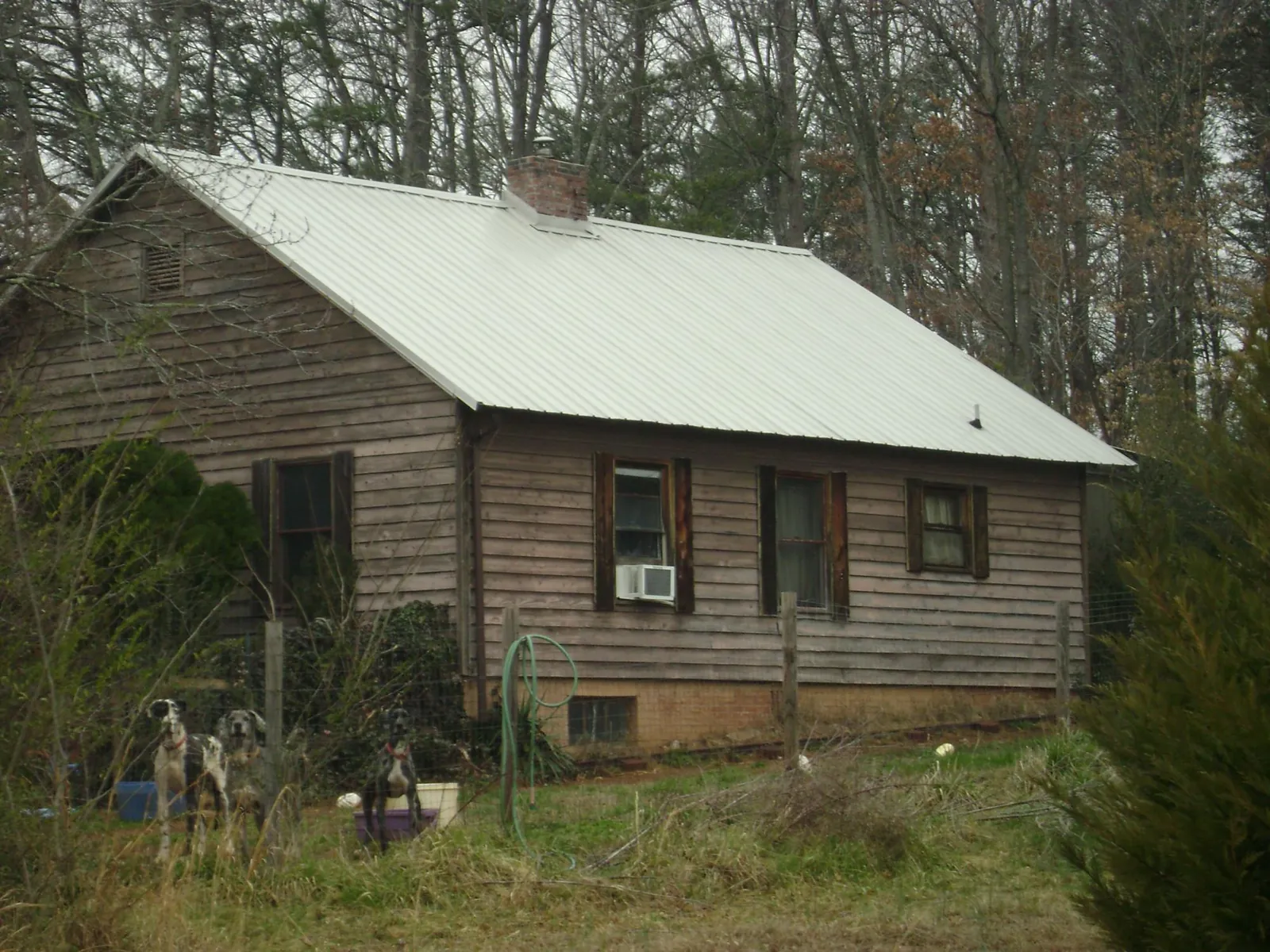 White metal roof on an old wood sided farmhouse, from a Metal Roof Installation job in Woodleaf